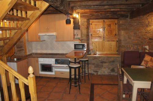 a small kitchen with a table and a stove at CASA EN BRAÑA VAQUEIRA EN OCCIDENTE DE ASTURIAS 