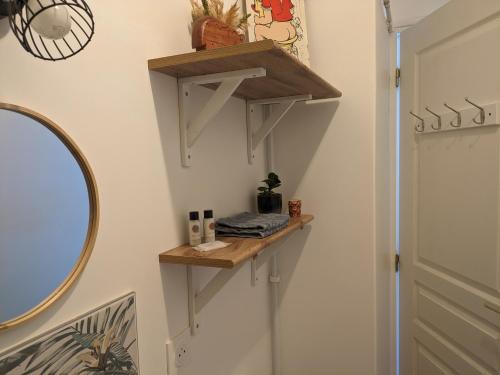 a bathroom with wooden shelves on the wall at Appartement Indépendant à Terrerort in Saumur