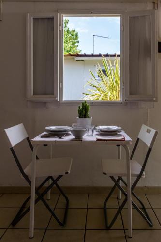 a white table and chairs in a kitchen with a window at La Conchiglia in Chioggia