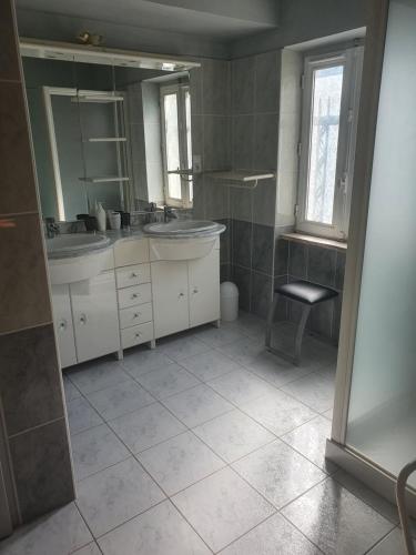 a bathroom with two sinks and a chair in it at le lorrain in Saint-Pons