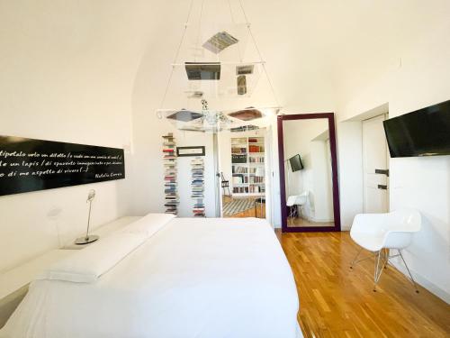 a white bedroom with a white bed and a mirror at La Casa del Poeta Enna - Pergusa in Enna