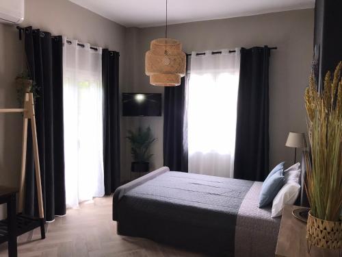 a bedroom with a bed with black curtains at Artemis Apartments in Diakopto