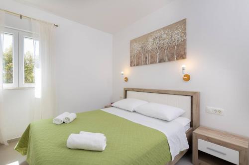 a bedroom with a bed with two towels on it at Apartments Laurea in Slano