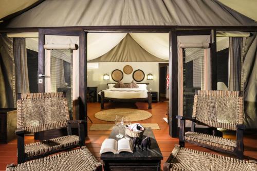 a bedroom with a tent with a bed and two chairs at Jagatpur Lodge by Annapurna in Khargauli