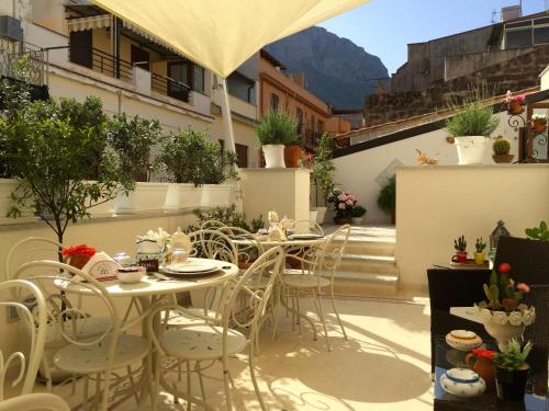 a patio with tables and chairs on a balcony at TAM Vacanze B&B in Cinisi