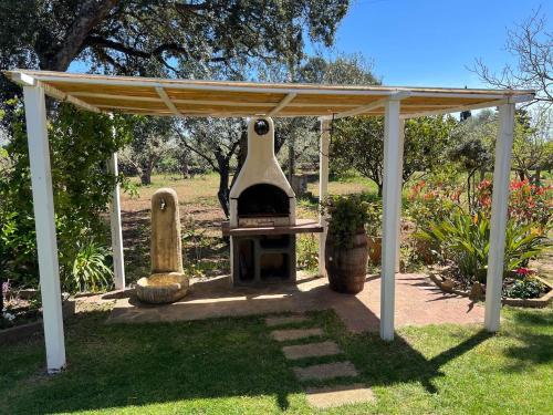 a barbecue under a pavilion in a garden at Putzurile House in Orosei