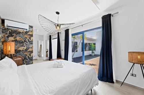 a bedroom with a white bed and a large window at Villalia Nerea in Playa Blanca