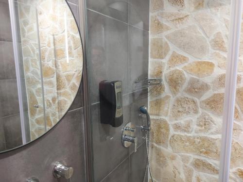 a bathroom with a shower with a mirror at The Santo George Beach Resort in Amoudara Herakliou