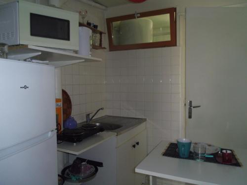 une petite cuisine avec un évier et un réfrigérateur dans l'établissement Chambre meublée sympa proche centre ville Lorient, à Lorient