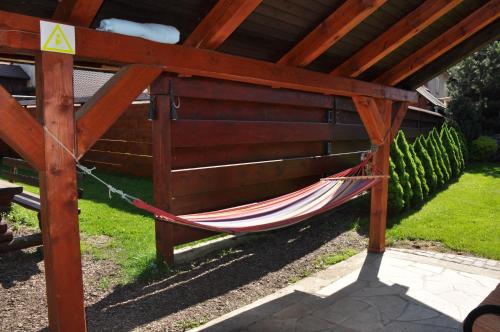 a hammock hanging from a wooden pergola at Apartmánový dom Slniečko in Žiar