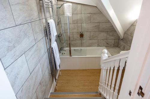 a bathroom with a shower and a bath tub at The Randolph Hotel in Southwold