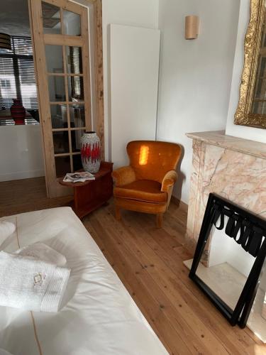 - une chambre avec un lit, une chaise et une cheminée dans l'établissement Circa 1929, à Ostende