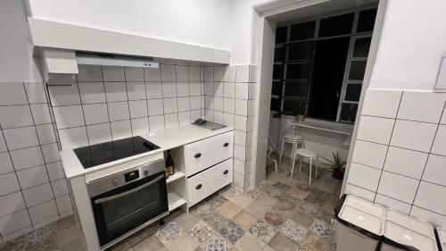 a white kitchen with a stove and a sink at SÓLO HABITACIÓN GRANDE CON BALCOn in Lisbon