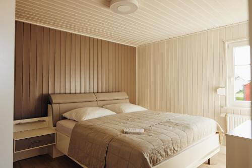 Un dormitorio con una cama grande y una ventana en Schorfheide - Ferienhaus mit Sauna und Hot Tub Whirlpool! Energiekosten flat, en Wandlitz