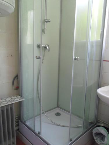 La salle de bains est pourvue d'une douche avec une porte en verre. dans l'établissement Chambre meublée sympa proche centre ville Lorient, à Lorient