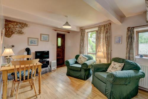 a living room with two chairs and a table at Duddings Country Cottages in Minehead