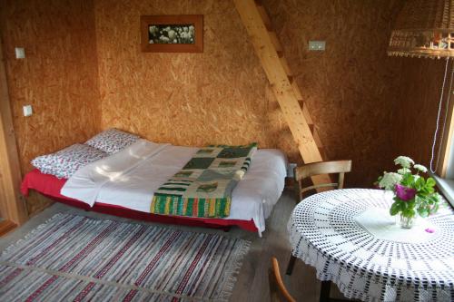 a small bedroom with a bed and a table at Türju rannamaja 
