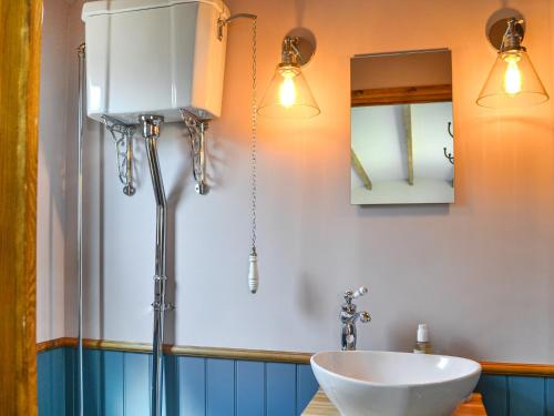 a bathroom with a sink and a mirror and lights at Wildflower View in Lowthorpe