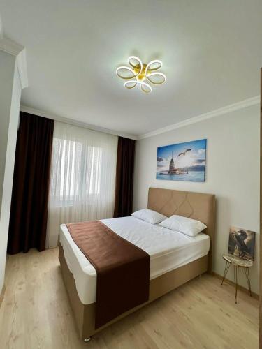 een slaapkamer met een groot bed en een plafondventilator bij TURGUT REZİDANS in Bostancı