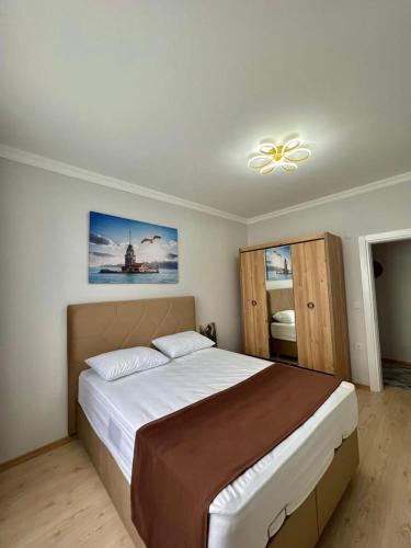 een slaapkamer met een groot bed en een plafondventilator bij TURGUT REZİDANS in Bostancı