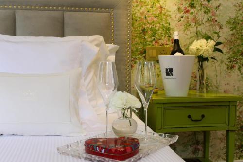 a bed with two glasses and a bottle of wine at HOTEL BOUTIQUE VILLA DEL MARQUÉS in Muros de Nalón