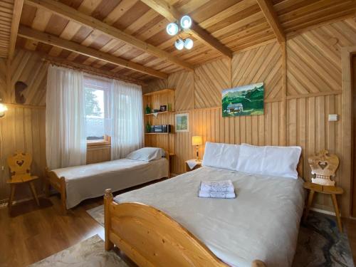 a bedroom with two beds in a wooden room at Pokoje u Kasi przy Dol. Chochołowskiej in Witów