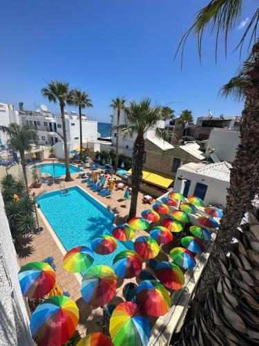 um monte de guarda-sóis coloridos ao lado de uma piscina em Kassavetis Center - Hotel Studios & Apartments em Hersonissos