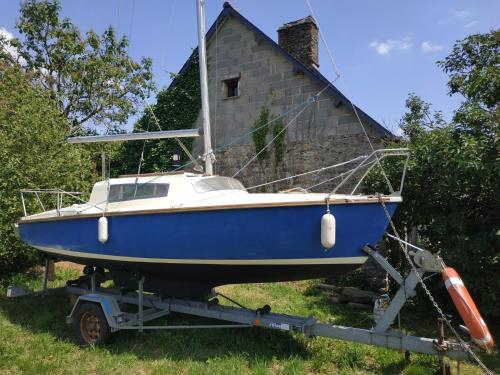 um barco azul em um trailer em frente a uma casa em Edel de la Touche Balard em Val Couesnon