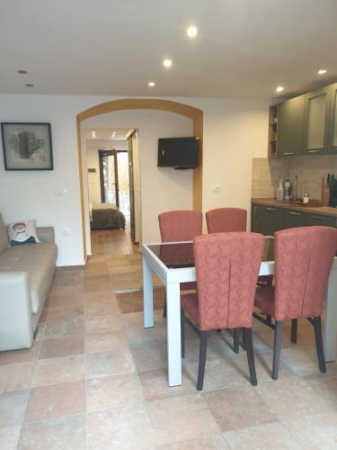 a kitchen and living room with a table and chairs at Apartma na klancu in Kobarid