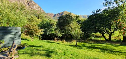 a bench in a field with mountains in the background at Gesail Barn and Farmhouse in Machynlleth