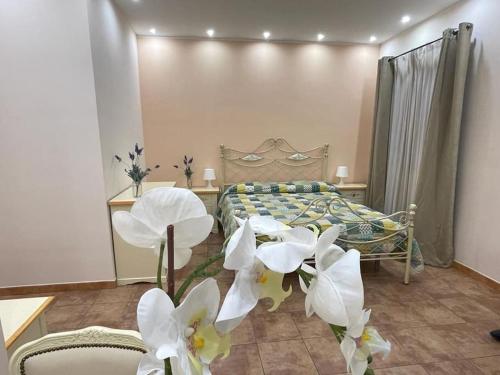 een slaapkamer met een bed met witte bloemen erin bij Casa Vacanze di Laura in Zafferana Etnea
