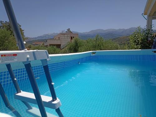 a swimming pool with a chair next to it at Chania Mini Villas in Skinés