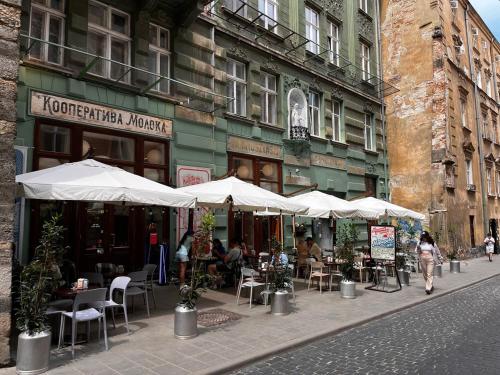 an outdoor cafe with tables and chairs and umbrellas at Apartaments near Ploshcha Rynok in Lviv