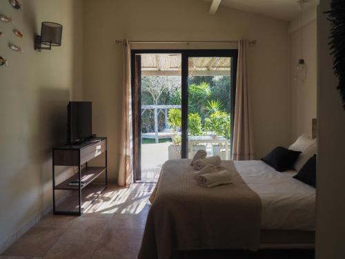 ボニファシオにあるSonges d’étéのベッドルーム1室(ベッド1台付)、スライド式ガラスドアが備わります。