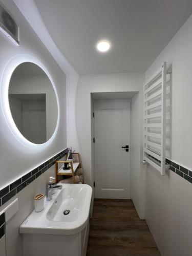 a white bathroom with a sink and a mirror at A8 Apartments Melnragė in Klaipėda