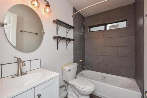 y baño con aseo, lavabo y espejo. en Charming 2-Bed Apartment in Houston en Houston