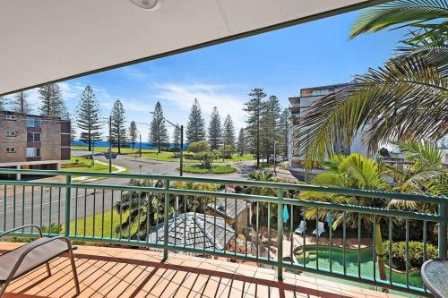 a balcony with chairs and a view of a park at Beachcalmer2 in Port Macquarie