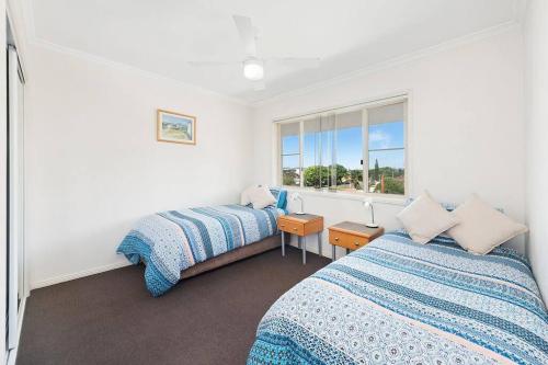 a bedroom with two beds and a window at Beachcalmer2 in Port Macquarie