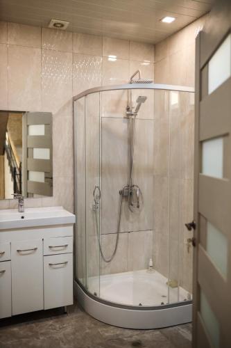 a bathroom with a shower with a tub and a sink at Sweet Home in Yengidzha