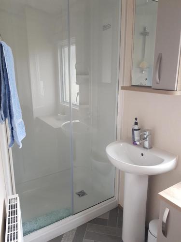 uma casa de banho com um chuveiro e um lavatório. em 2 Bedroom Lodge, Milford on Sea em Milford on Sea