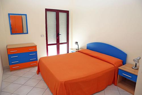 1 dormitorio con 1 cama naranja y 1 silla azul en Residence Soleluna, en Praia a Mare