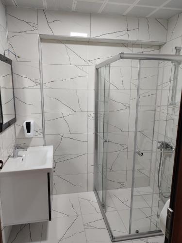 a bathroom with a glass shower and a sink at Karagöz Süit in Uzungöl