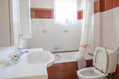 Un baño con lavabo, inodoro y bañera. en Seaside Villa, en Alexandroupoli