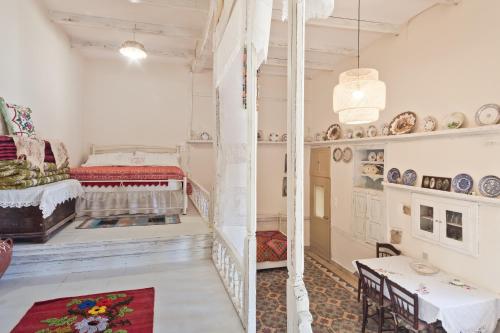 a white room with a bed and a table at Traditional Karpathian house in Karpathos Town