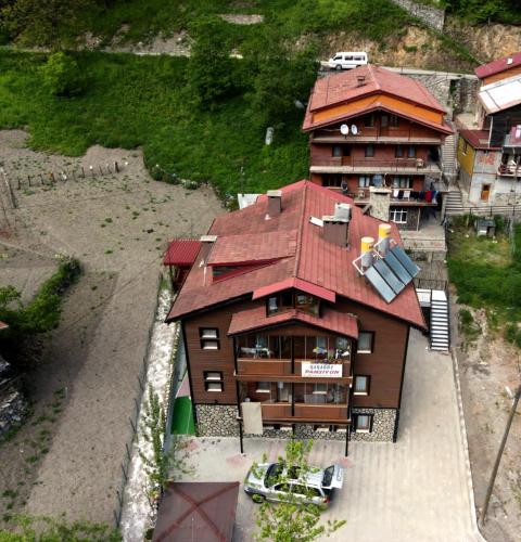 a large building with a red roof and a house at Karagoz Apart Pansiyon in Uzungol