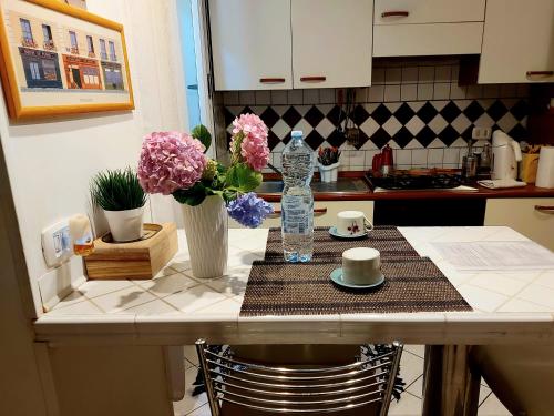 a kitchen counter with a table with flowers on it at Delizioso appartamento Frosinone centro storico in Frosinone