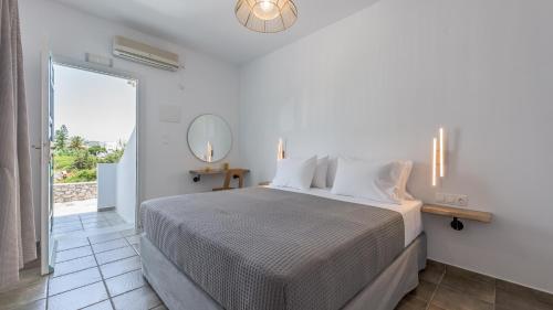 a bedroom with a bed and a large window at Michalis Studios in Pollonia