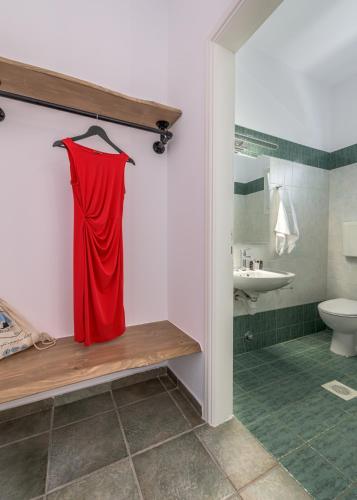 a red dress hanging on a wall in a bathroom at Michalis Studios in Pollonia