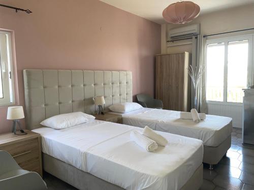 a bedroom with two beds with white sheets at Andreas Studios in Svoronata