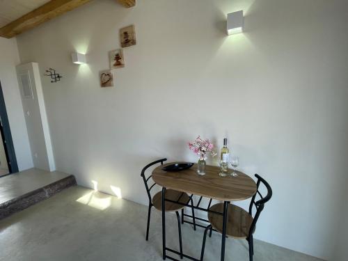 a table and chairs in a room with a wall at The Stone House in Votsi